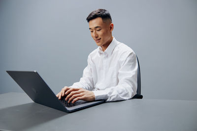 Young man using laptop while sitting on table