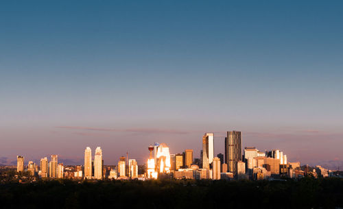 Buildings in city against clear sky