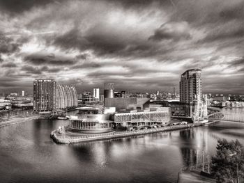 Buildings in city against cloudy sky