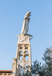 Low angle view of statue against clear blue sky