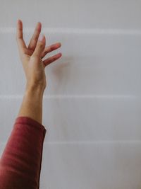 Close-up of hand against wall