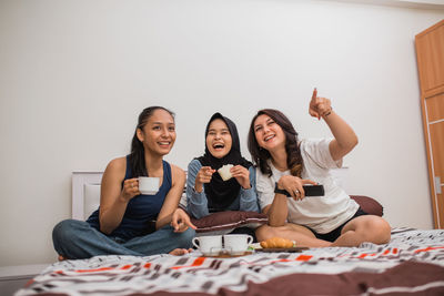 Portrait of smiling friends sitting at home