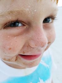 Close-up portrait of boy with sand on face