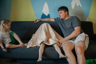Side view of woman sitting on sofa at home