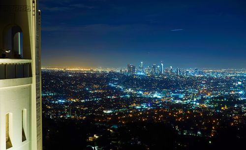 Illuminated cityscape against sky at night