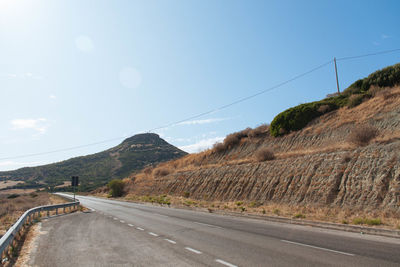 Road by mountain against sky