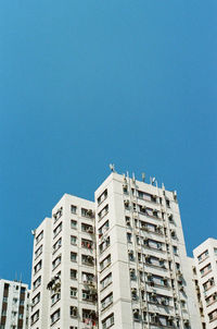 Low angle view of buildings against clear blue sky