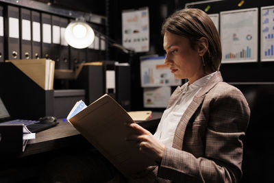 Side view of businesswoman using laptop at office