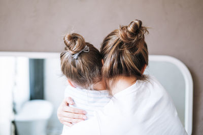 Young mother woman with long hair with little tween girl daughter having fun in the morning at home