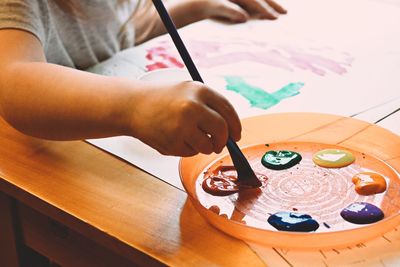 Close-up of child painting with watercolor