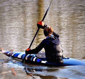 Rear view of woman with boat in lake