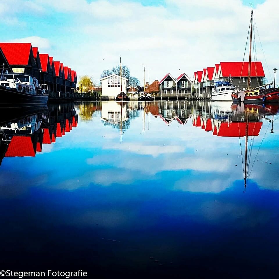 water, reflection, architecture, built structure, building exterior, sky, waterfront, nautical vessel, moored, lake, cloud - sky, standing water, red, river, boat, day, cloud, outdoors, city, no people