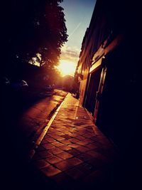 Street amidst buildings against sky during sunset