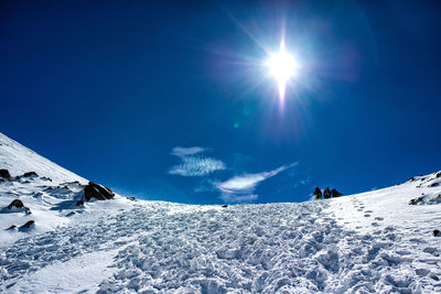 Scenic view of snowcapped mountains against blue sky