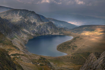 High angle view of river amidst mountains against sky