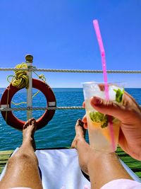 Midsection of man drinking glass against sea