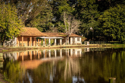 House by lake against sky