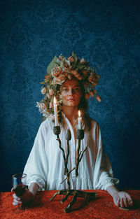 Portrait of woman standing against black background