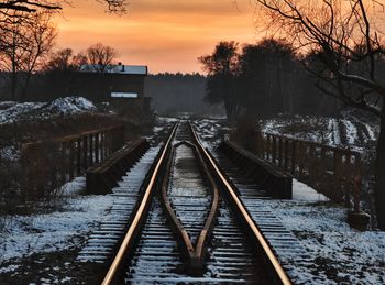 High angle view of railroad tracks by canal during winter