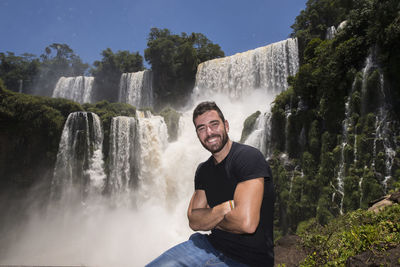 Young man posing in front of the iguacu waterfalls in argentina