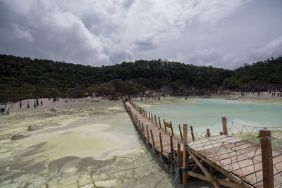 Scenic view of beach against cloudy sky