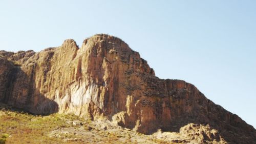 Rock formations on landscape against clear sky