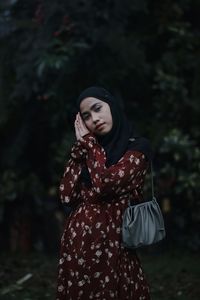 Portrait of woman standing against woods