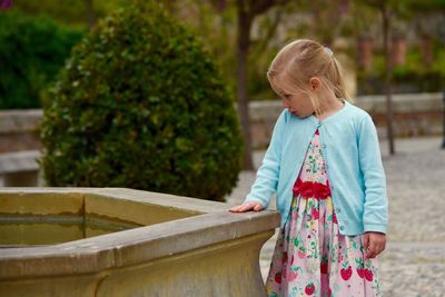 Girl looking at fountain in park