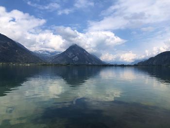 Scenic view of lake by mountains against sky