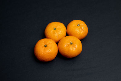 High angle view of orange fruits on black background