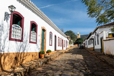 Footpath amidst buildings against sky