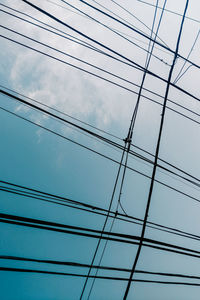 Low angle view of power cables against sky