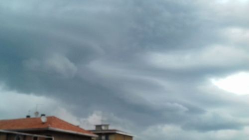 Low angle view of storm clouds over roof
