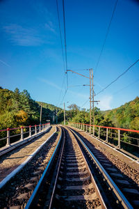 Railway tracks against clear blue sky