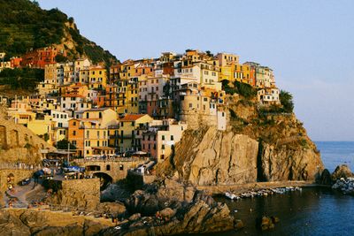 Buildings by sea against clear sky