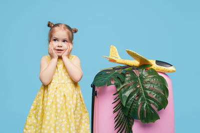 Portrait of girl standing against blue background