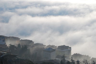 High angle view of foggy town with clouds