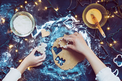 High angle view of hands making christmas cookies