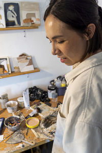 Side view of young woman having food at home