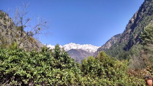 Scenic view of mountains against clear blue sky