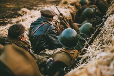 Rear view of men sitting on field