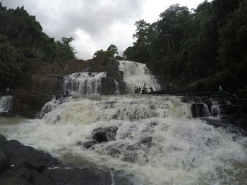 Scenic view of waterfall against sky