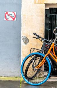 Bicycle sign on road against building