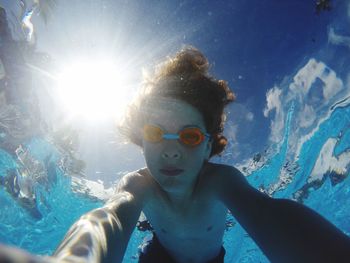 Low angle view of shirtless boy swimming in pool