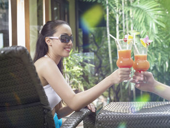 Close-up of couple toasting drink at resort against trees