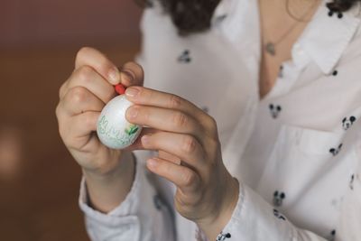 Midsection of woman decorating easter egg