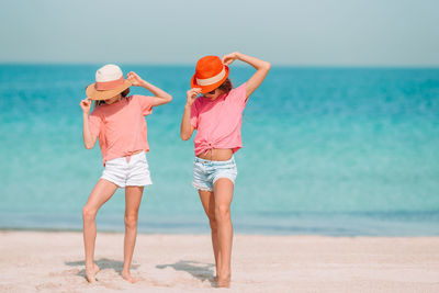 Rear view of women on beach against sea