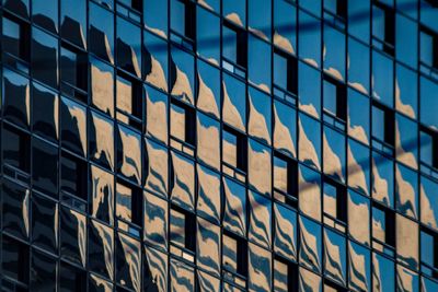 Low angle view of modern glass building in city