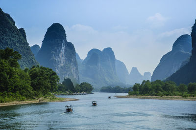 Scenic view of river and mountains against sky