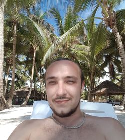 Portrait of smiling young man with palm tree